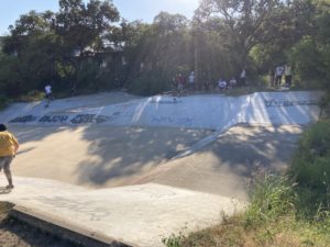 people skateboarding in a big drainage ditch
